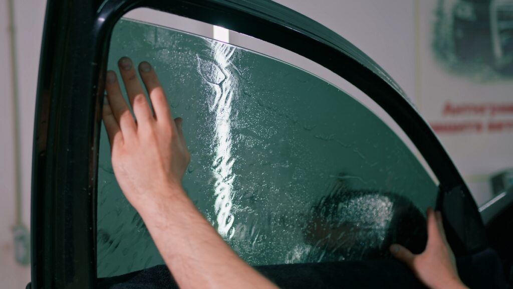 Professional Window Tint Specialist Precisely Applying Tint Film on a Car for Sun Protection and Privacy