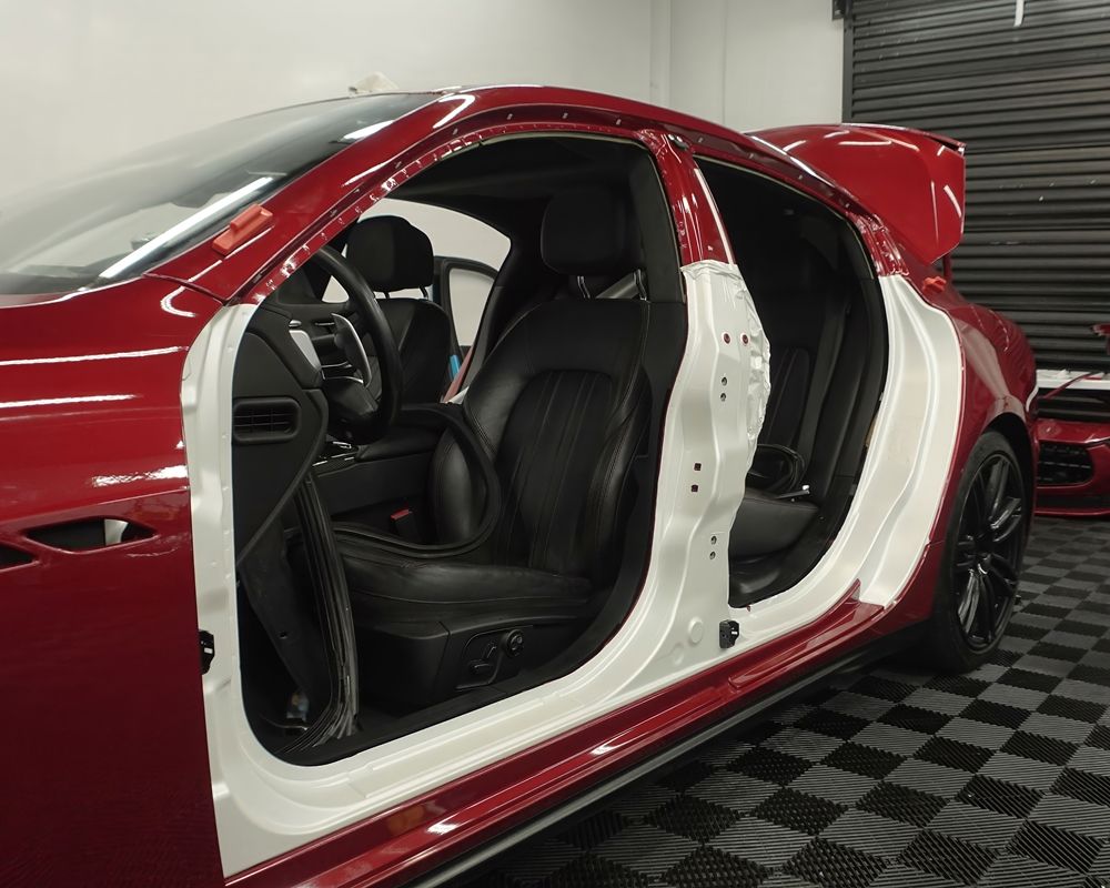 Red Maserati Quattroporte Undergoing Color Change with White Vinyl Wrap at Villar Auto Pros Garage