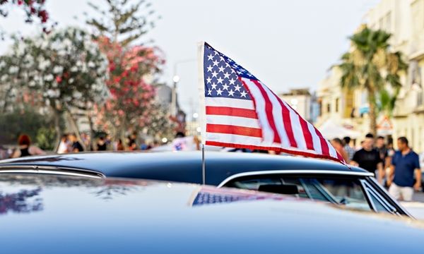 Classic vintage car decorated with the American flag, celebrating the 4th of July weekend with patriotic flair – Villar Auto Pros supports your automotive passion this Independence Day.
